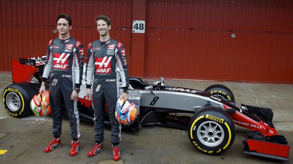 Drivers Esteban Gutiérrez and Romain Grosjean with the team's car.